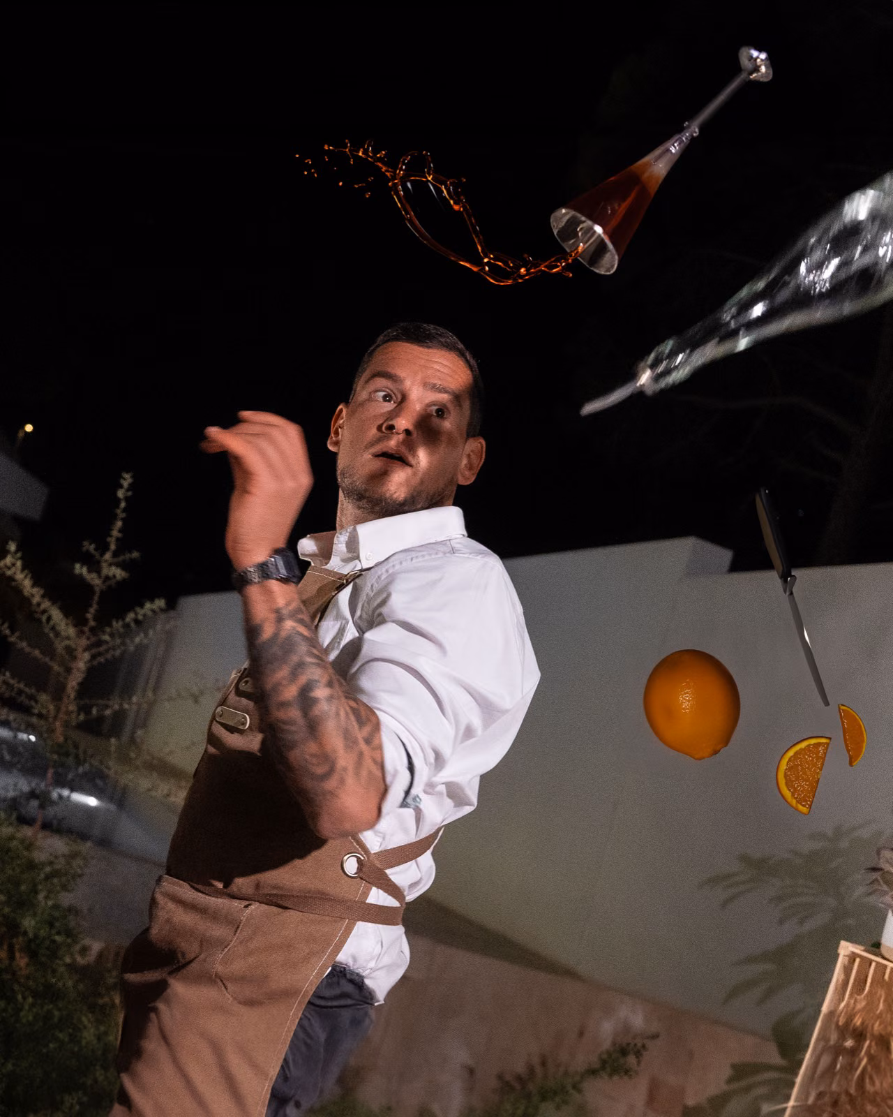 Manuel Scorza haciendo flair con una naranja en el aire al atardecer tras la barra portátil de Sip n' Chill en Málaga