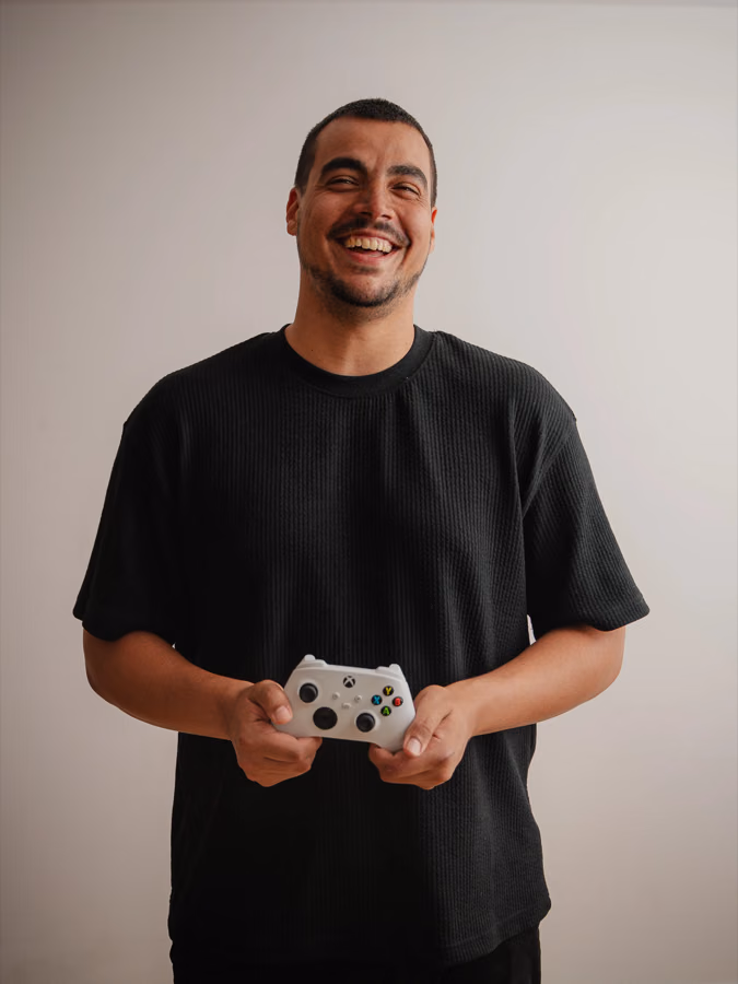 Joaquín González smiling with a white Xbox controller during his personal brand session