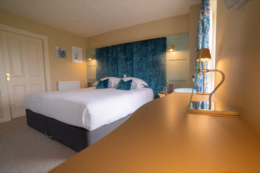 Hotel bedroom with a teal velvet headboard at The Mallard Hotel, Gullane