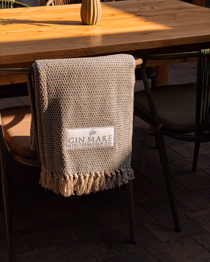 Gin Mare branded towel on a chair in The Courtyard at The Ship Inn, Musselburgh